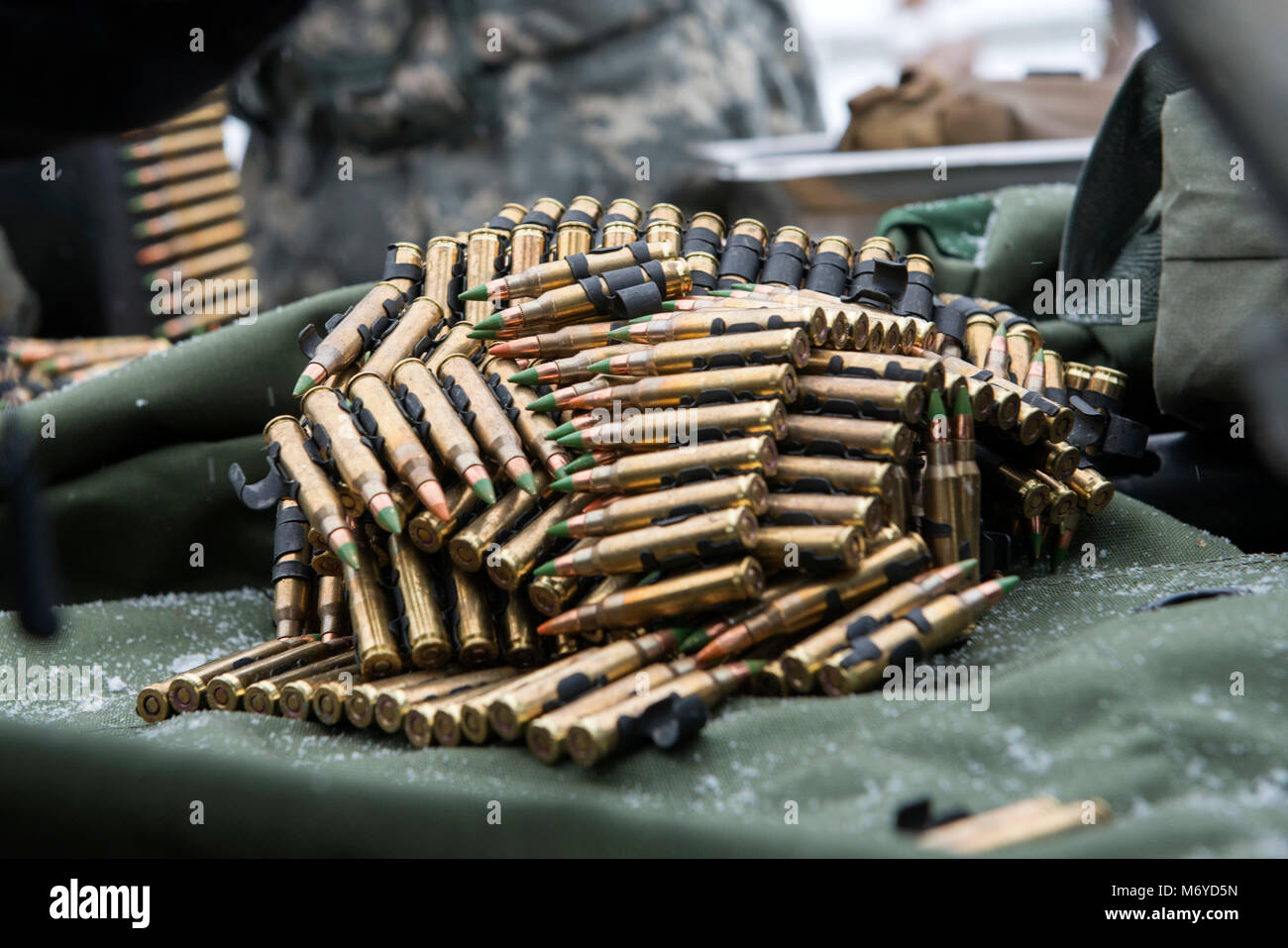 Strisce di 5,56 mm munizioni sono raccolti da Alaska Esercito Nazionale soldato di guardia, assegnato il segnale 297Company, durante M249 Light machine gun live-formazione antincendio a base comune Elmendorf-Richardson, Alaska, 3 marzo 2018. Questo corso di formazione ha garantito che le Alaska guardie nazionali ha mantenuto un elevato livello di professionalità e la prontezza a rispondere come richiesto sia stato e le chiamate nazionali. (U.S. Air Force foto di Alejandro Peña) Foto Stock