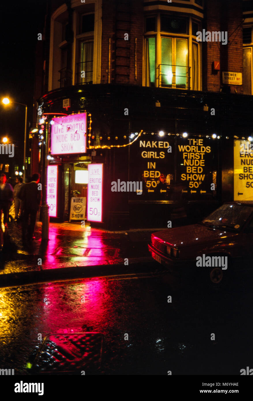 Vivere erotico letto nudo mostrano porta ingresso su angolo di Brewer Street nel quartiere di Soho, London W1, su una notte ad umido in 1988, Inghilterra Foto Stock