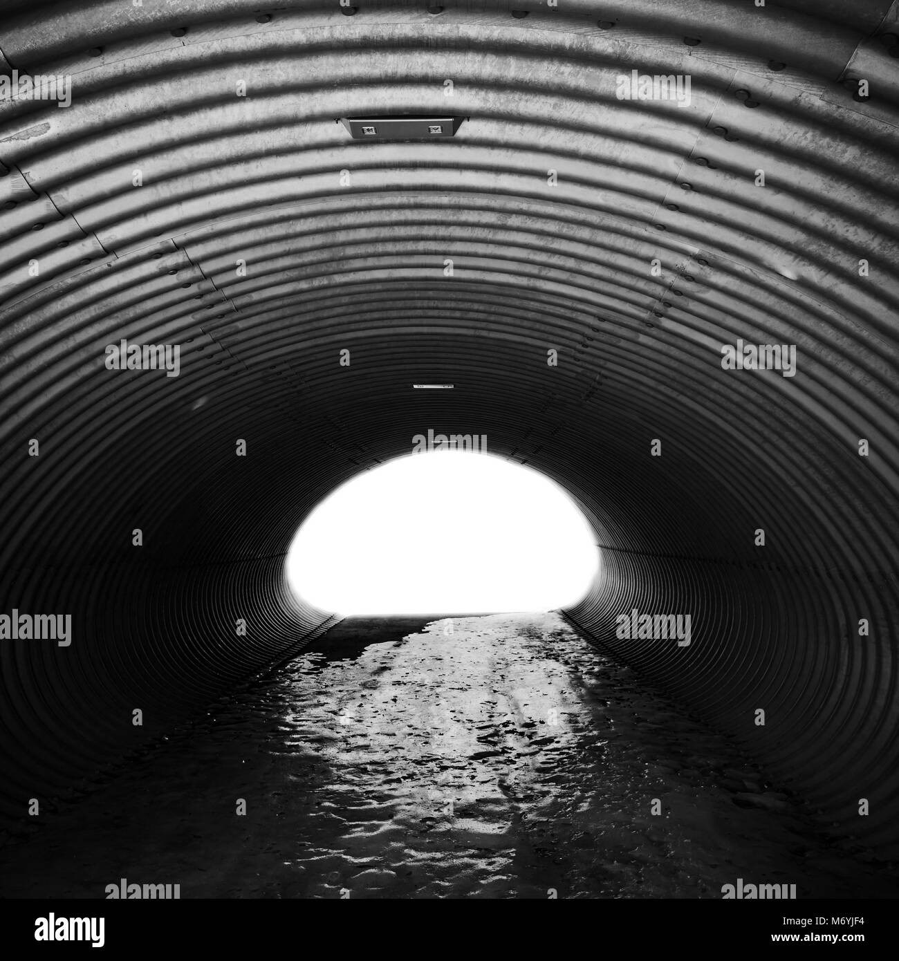 Acciaio ondulato corridoio con estremità incandescente e un terreno ghiacciato, tunnel industriali, quadrato nero e sfondo bianco Foto Stock
