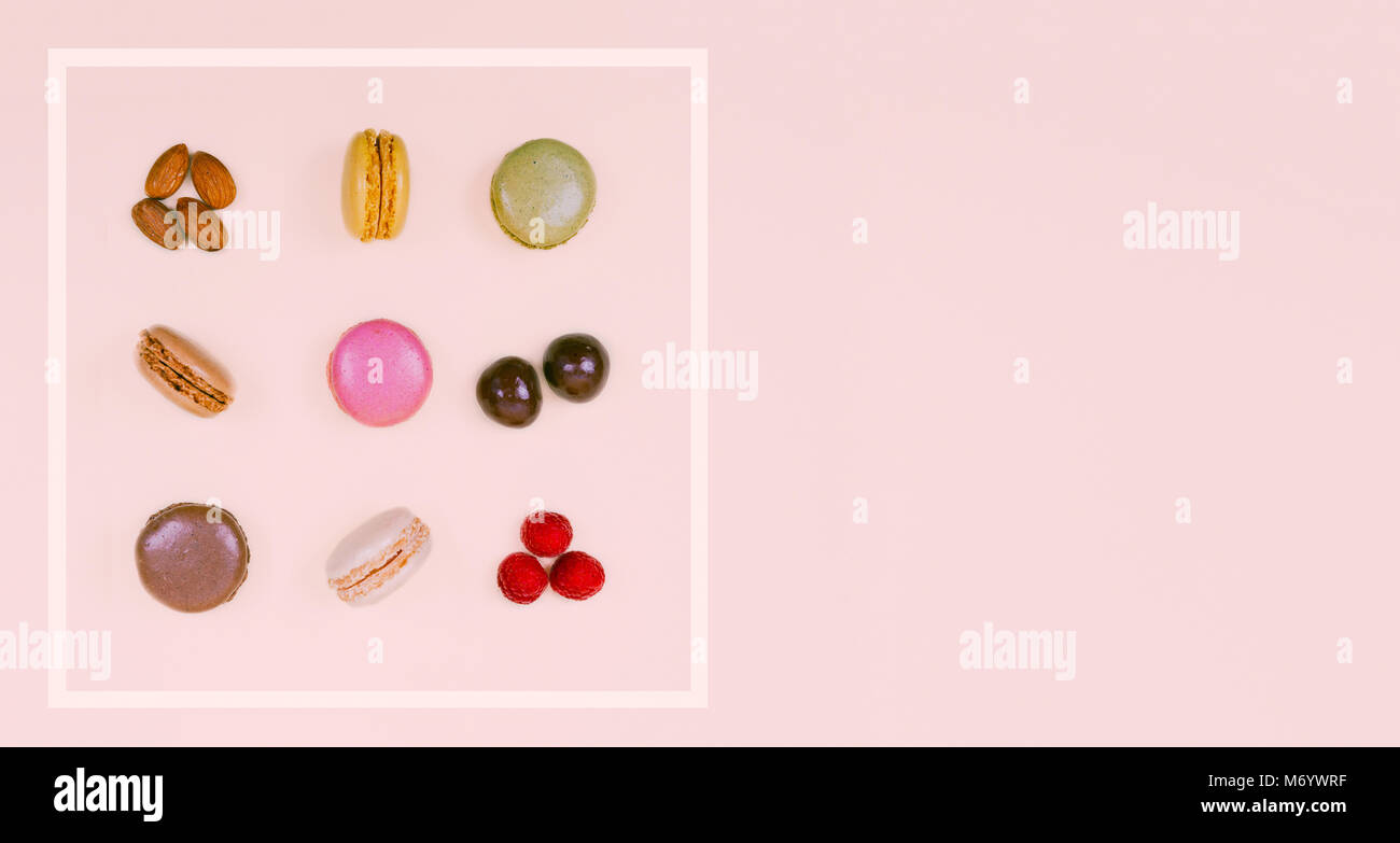 Amaretti colorati in rosa pastello sfondo. Foto Stock