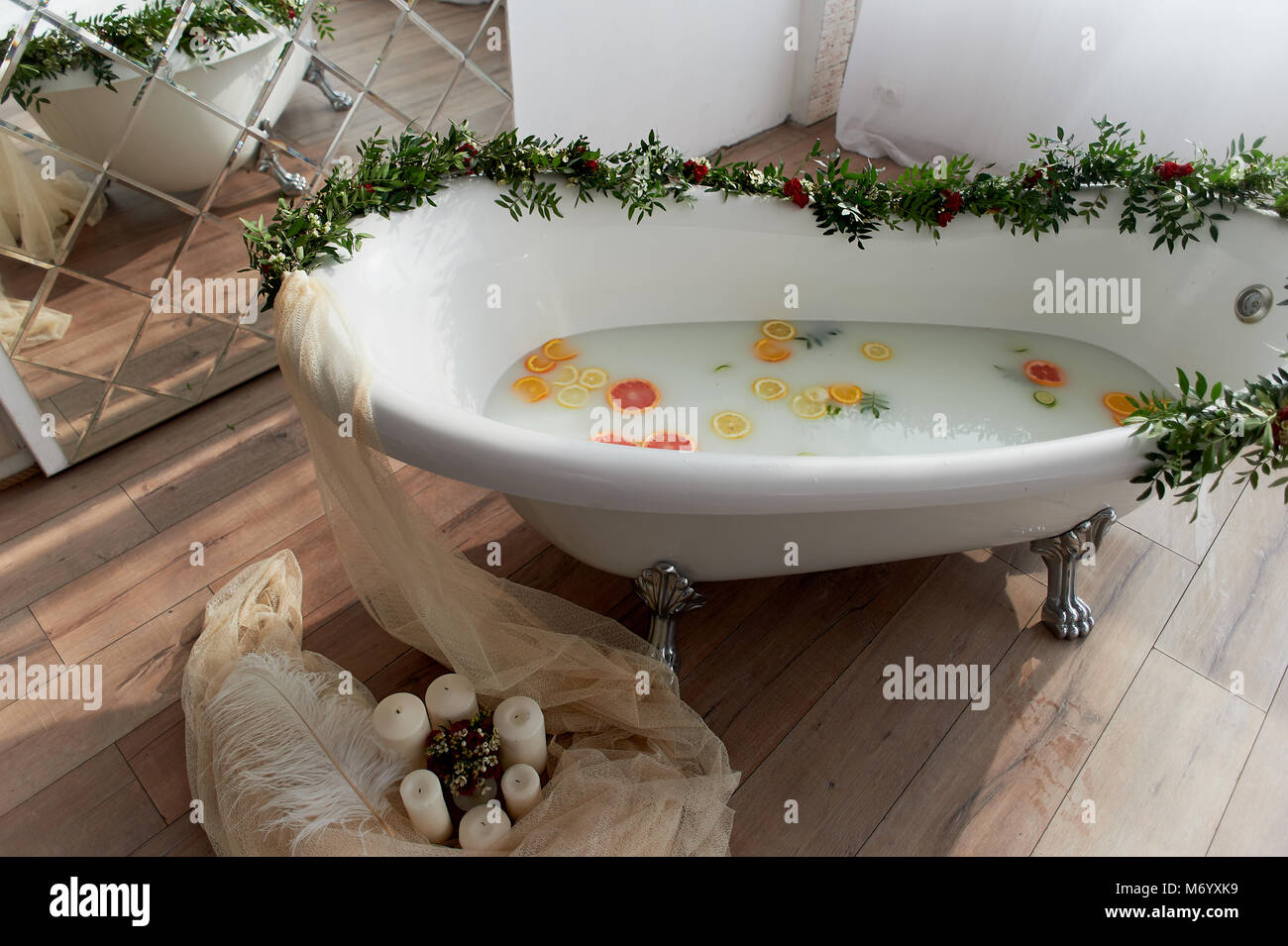 Elegante roll-top vasca da bagno e decorate con fiori. In acqua nuotare citrus.L'atmosfera di relax, relax Foto Stock