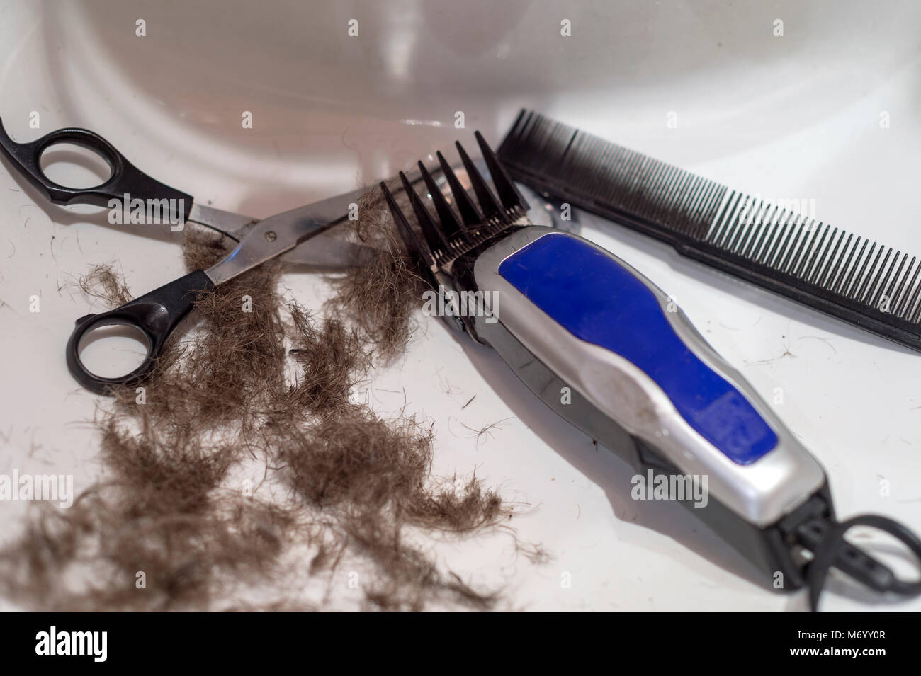 Lavandino Con tosatrici, forbici e pettine. Home taglio di capelli. Foto Stock