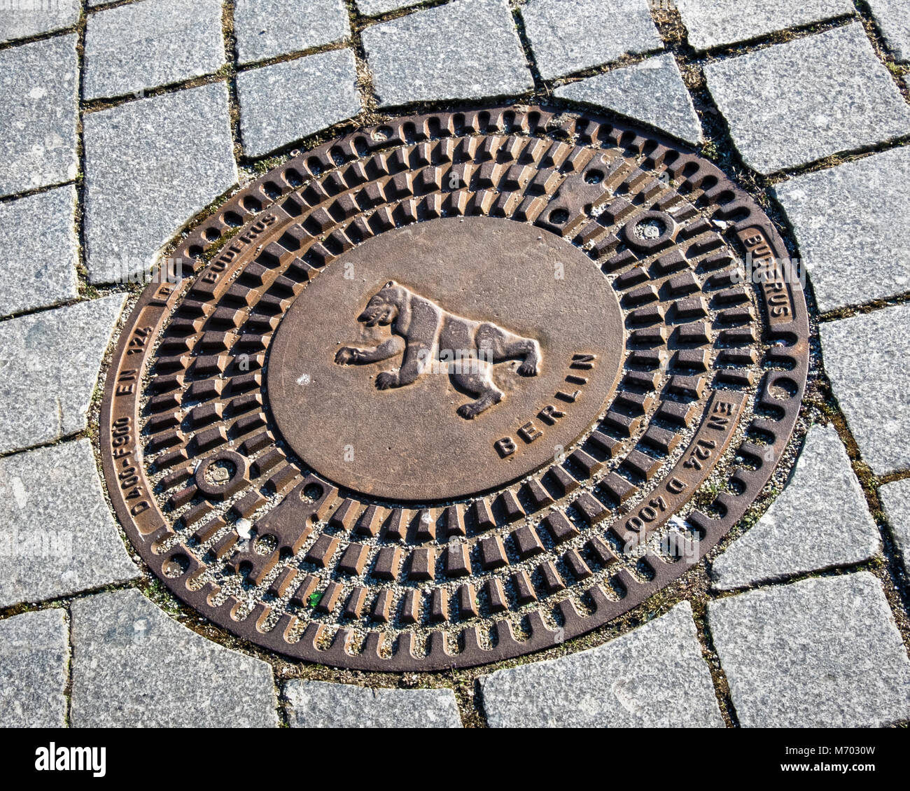 Berlino, Mitte. Coperchio di scarico con Berlino Orso emblema del Logo nella pavimentazione di ciottoli Foto Stock