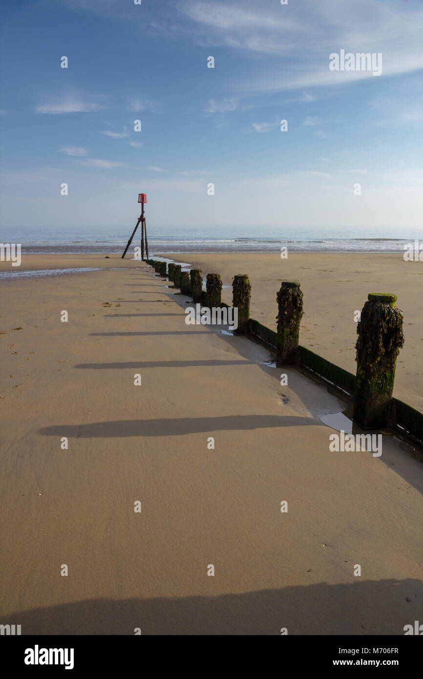 Groyne nella sabbia con un pennarello rosso alla fine, Yaverland, Sandown, Isle of Wight, Regno Unito Foto Stock