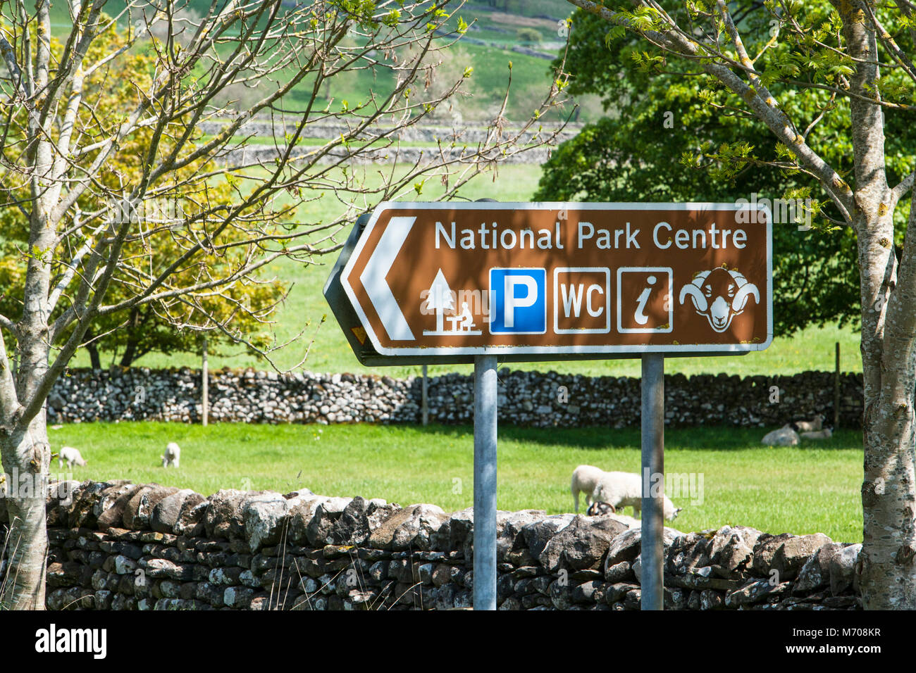 Un segnale di informazione nel Yorkshire Dales villaggio di Malham North Yorkshire Regno Unito, indirizzare i visitatori al centro del Parco Nazionale e area di servizio è Foto Stock