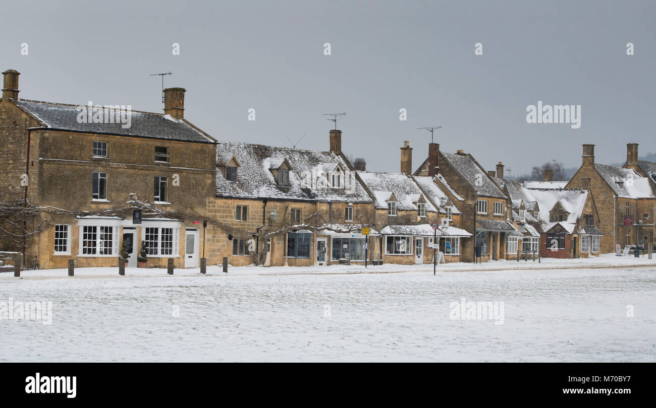 Negozi di High Street a Broadway nella neve d'inverno. Broadway, Cotswolds, Worcestershire, Inghilterra. Panoramica Foto Stock