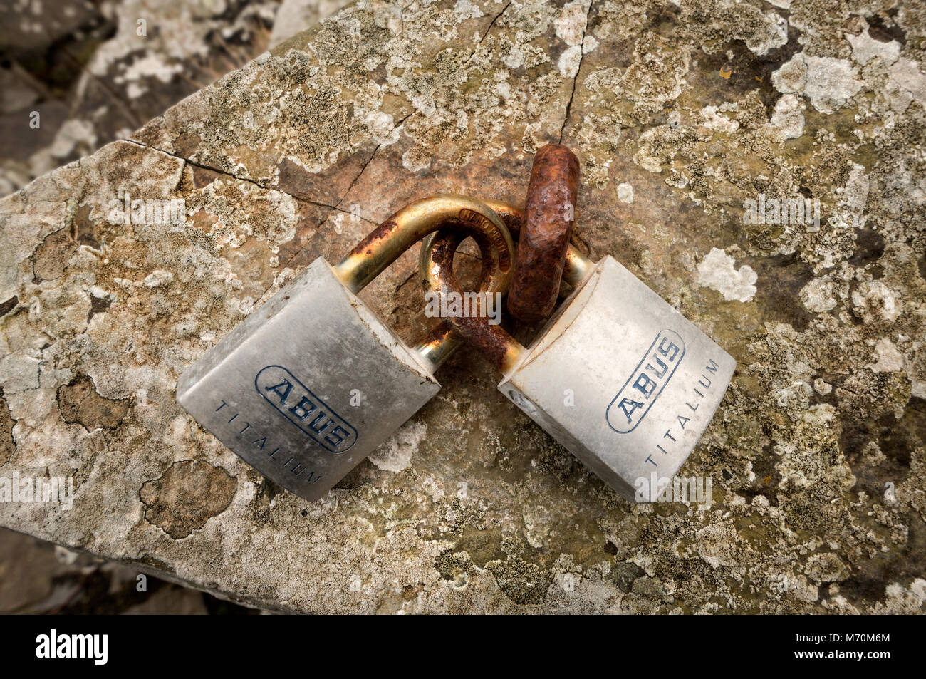 Un paio di lucchetti attaccati ad un anello arrugginito. Foto Stock