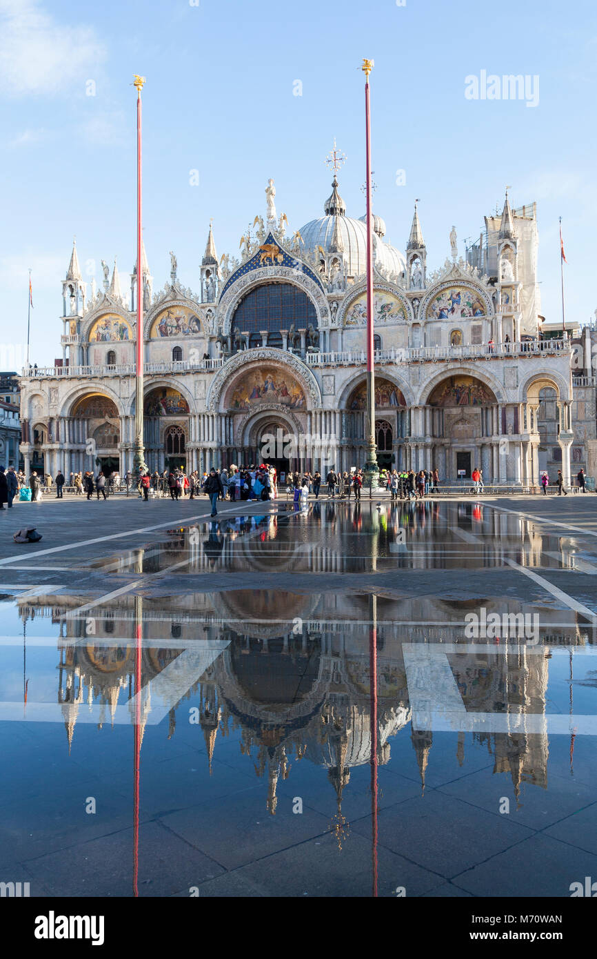 Basilica di San Marco si riflette in acqua alta in Piazza San Marco, Piazza San Marco, San Marco, Venezia, Veneto, Italia in una giornata di sole con cielo blu. Foto Stock