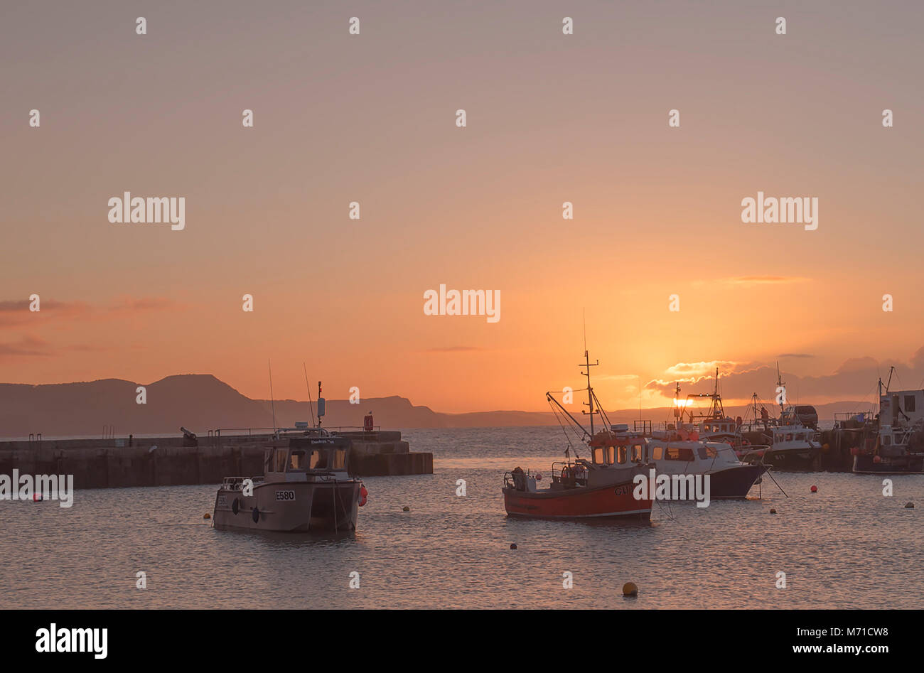 Lyme Regis, Regno Unito. 8 Marzo, 2018. Regno Unito: Meteo incandescente sole primaverile oltre lo storico porto di Cobb alla stazione balneare di Lyme Regis. Credito: Celia McMahon/Alamy Live News Foto Stock