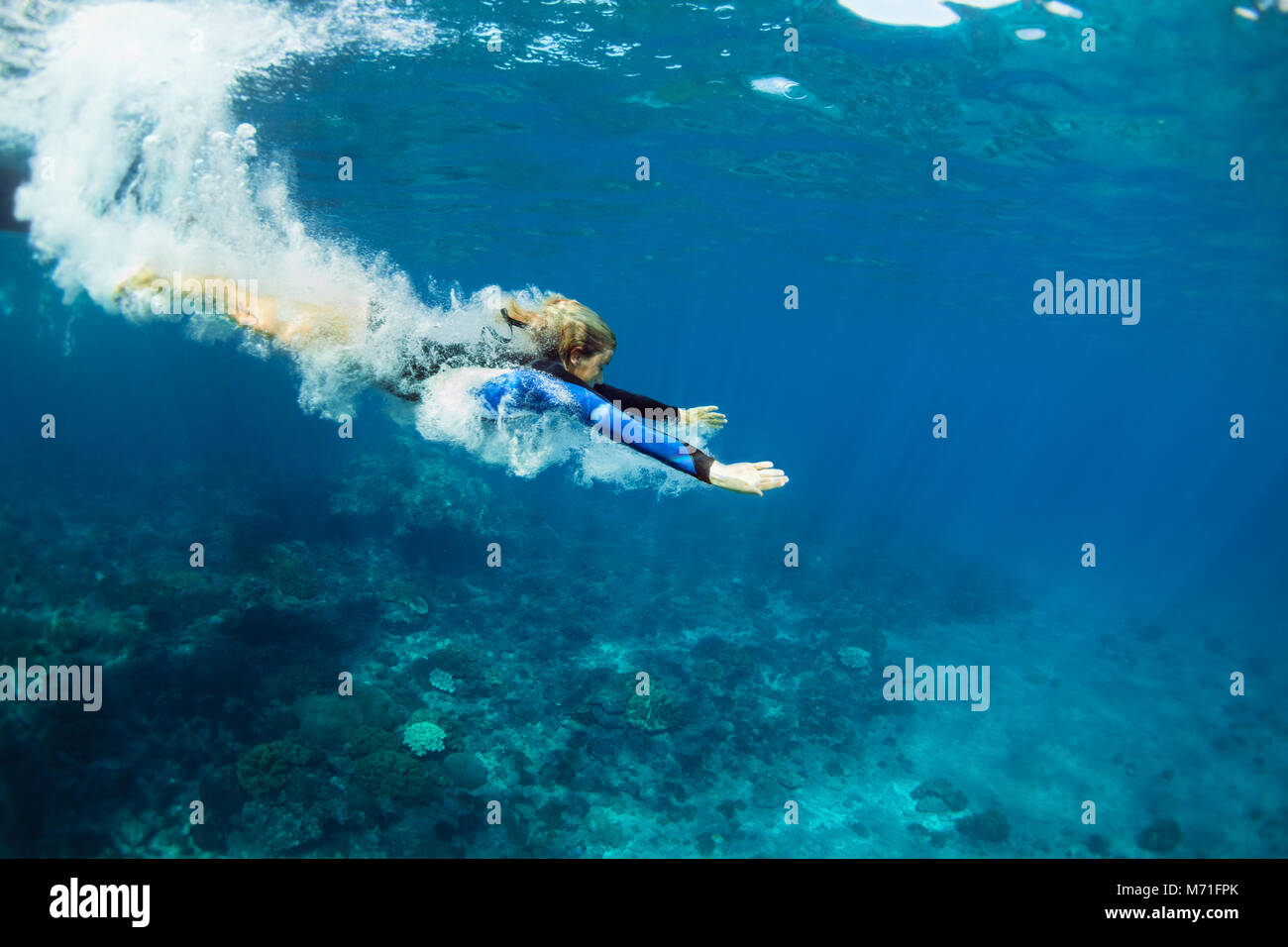 La famiglia felice - attivo ragazza adolescente saltare e tuffarsi underwater in tropical Coral reef piscina. Lo stile di vita di viaggi, sport d'acqua, snorkeling avventura. Foto Stock