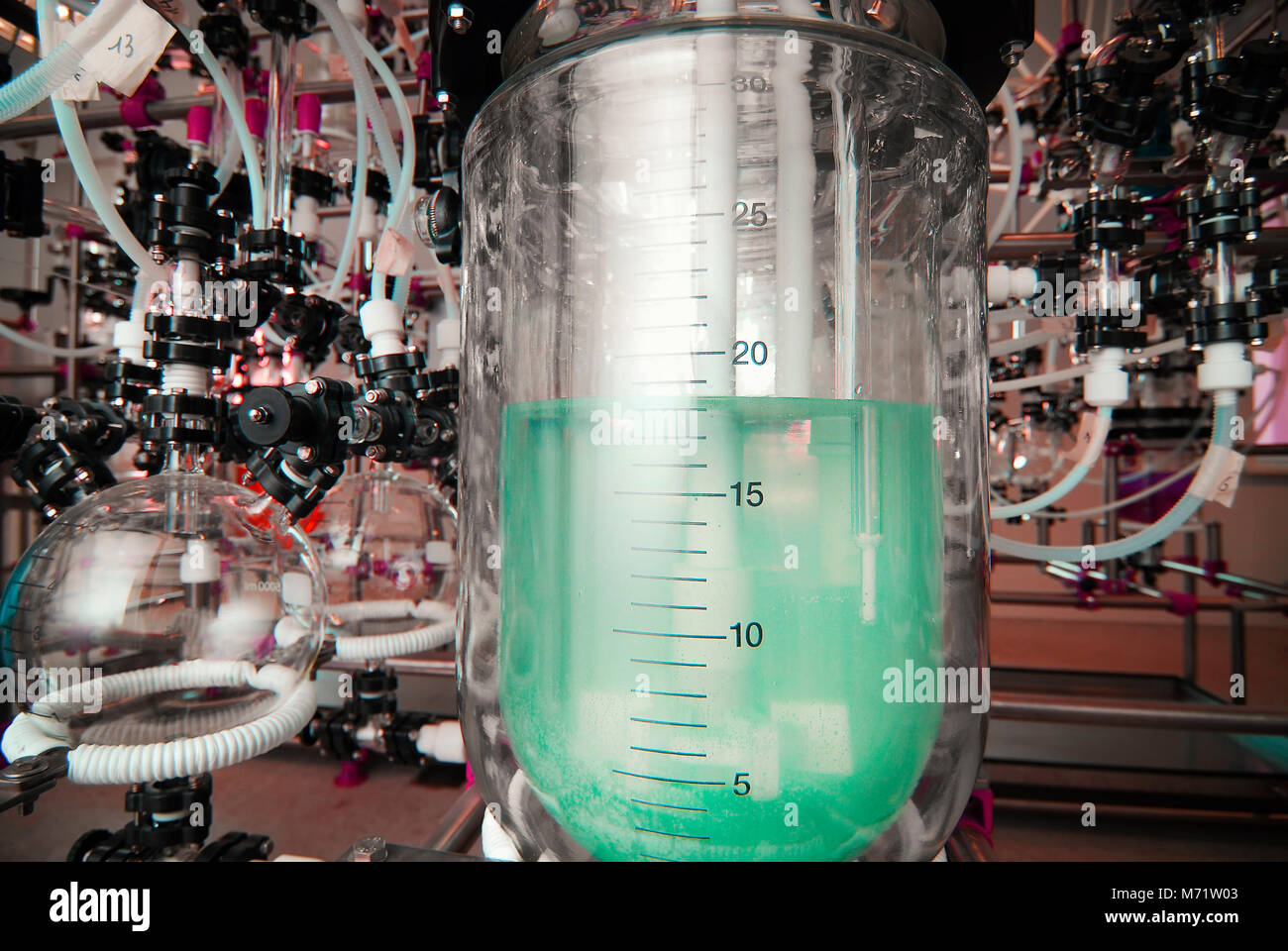 Fabbricazione di medicinali a un farmaco fabbrica. liquido verde in un pallone Foto Stock