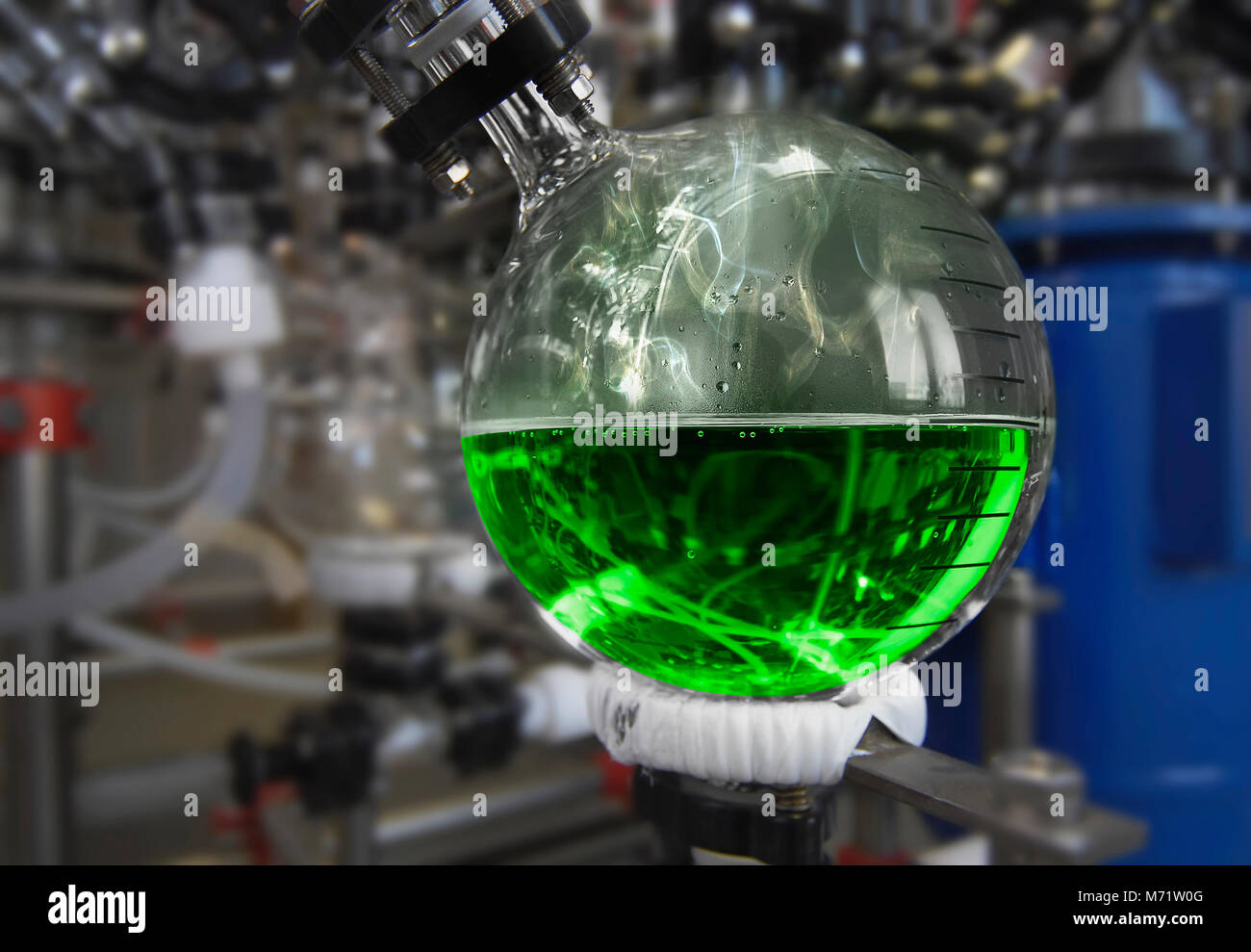 Fabbricazione di medicinali a un farmaco fabbrica. liquido verde in un pallone Foto Stock