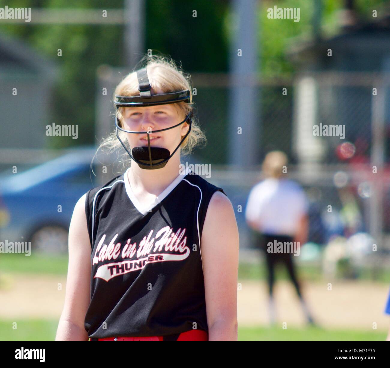 Fastpitch softball player è il pensiero del grande gioco che ha appena fatto. Questa foto è stata scattata nel nord dell'Illinois in estate. Foto Stock