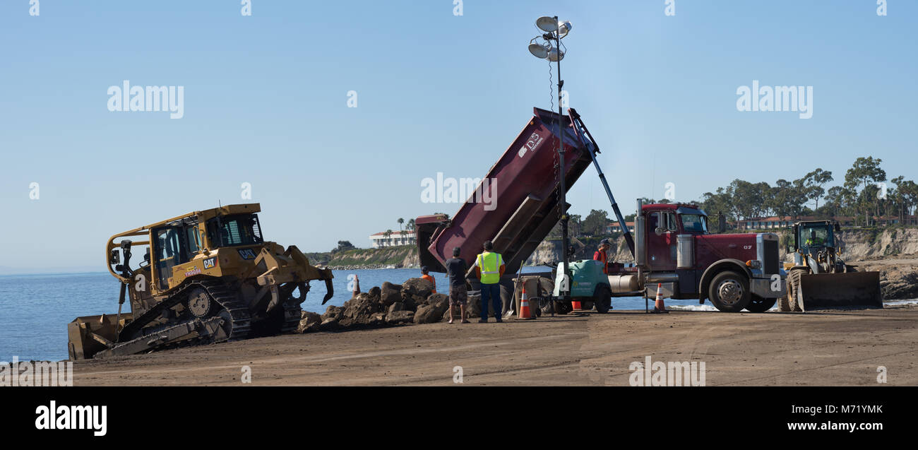 Santa Barbara, Stati Uniti - Febriary 16, 2018: Bulldozer e camion scarico off-inondazioni lo sporco da Montecity fuoco e tempesta di pioggia, in P Foto Stock