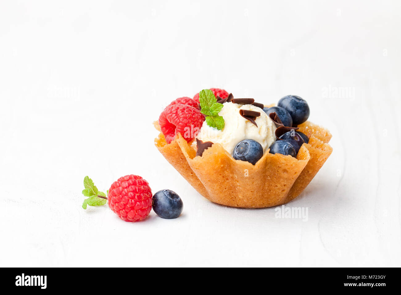 Il brandy scatta il cestello con gelato e frutti di bosco su sfondo bianco Foto Stock