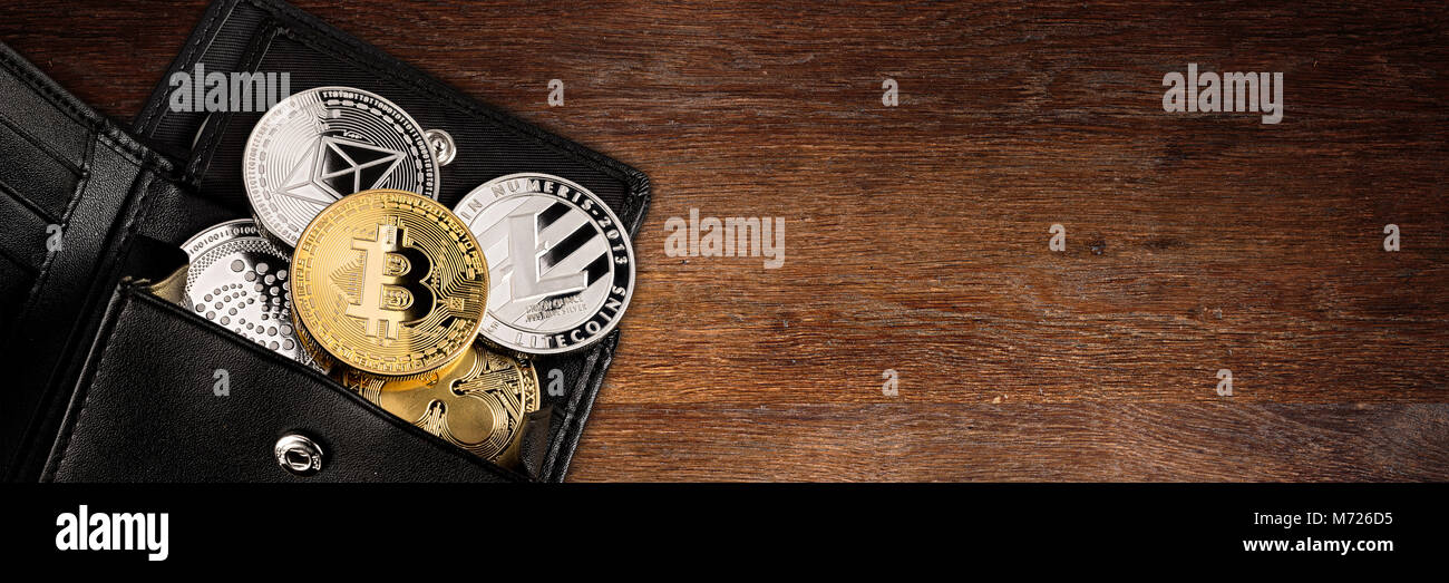 Crypto valuta moneta in nero portafoglio in pelle su vasta in legno panorama con sfondo spazio copia ethereum bitcoin litecoin iota ripple Foto Stock