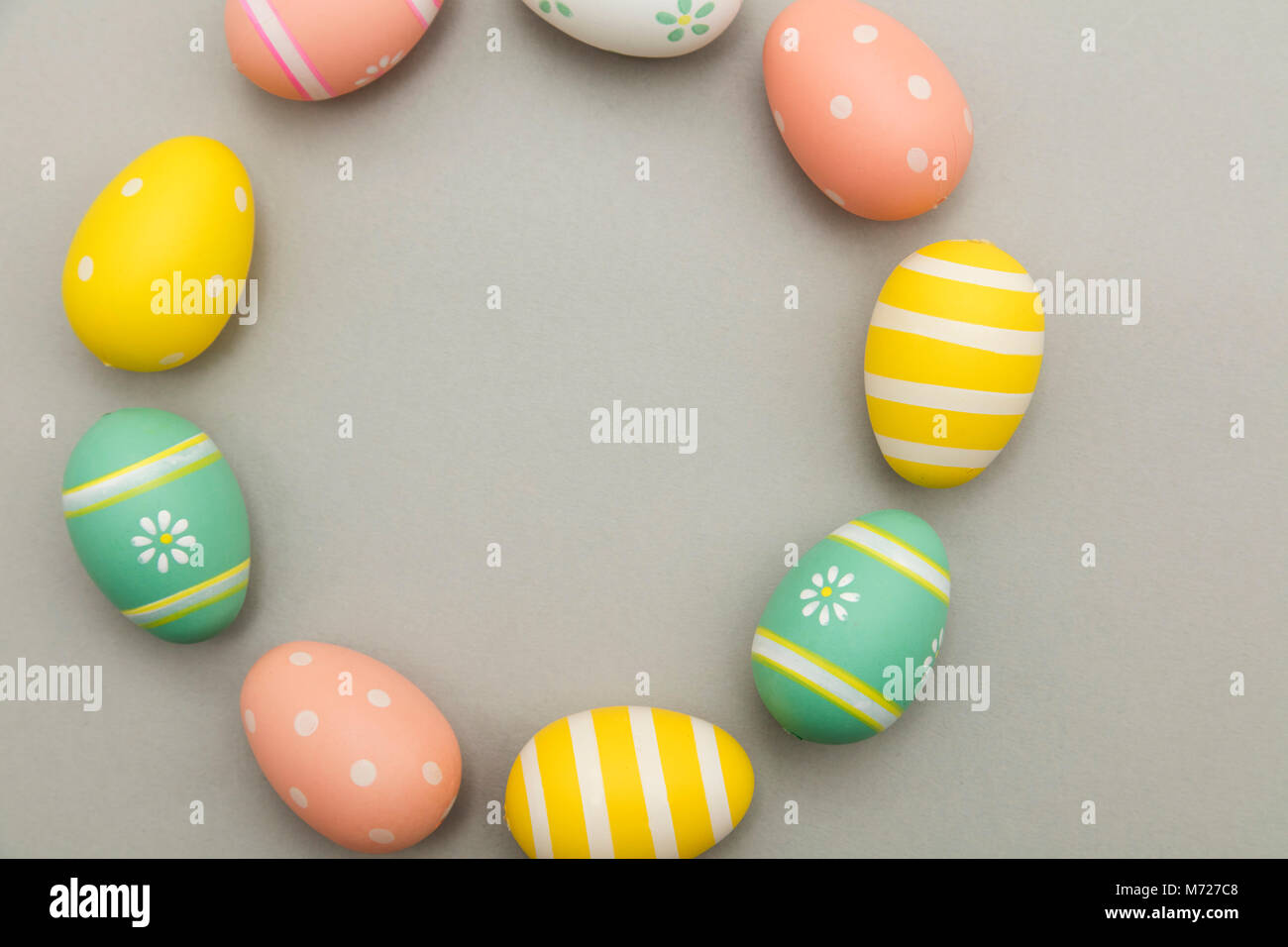 Vacanze di Pasqua sfondo. Color pastello decorate le uova di pasqua su sfondo grigio Foto Stock