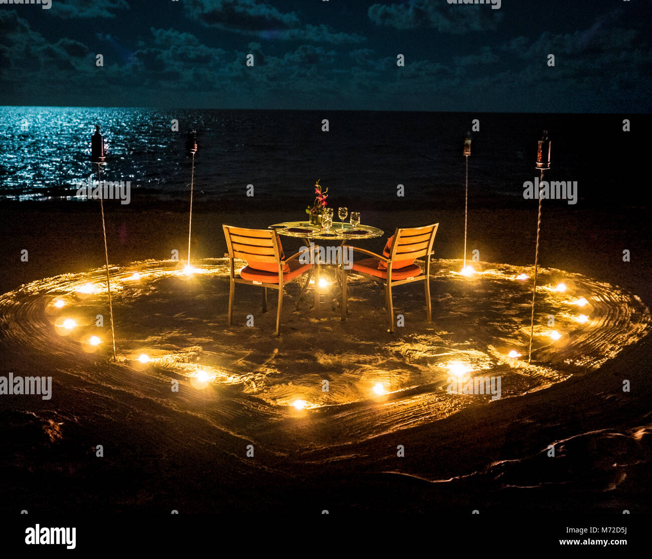 Beachside cena a lume di candela per due in Messico con torce tiki e Luna su una serata perfetta in Quinta Roo Foto Stock