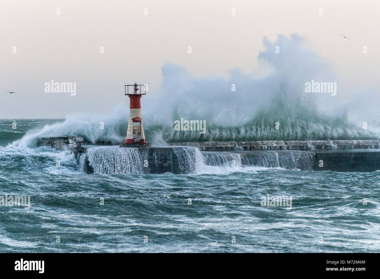 Onde enormi visto schiantarsi contro il frangiflutti di Kalk Bay Harbor in Cape Town, Sud Africa. Le onde erano il risultato di due giorni di alta w Foto Stock