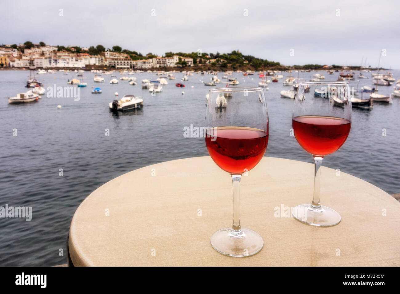 Due gas di rose sul tavolo, con porto in background, Cadaques, Alt Emporda comarca in Costa Brava Catalogna Foto Stock