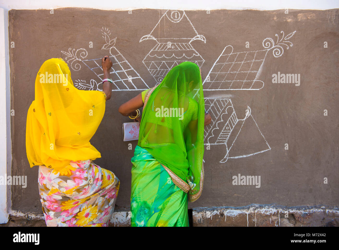 Pushkar / India 27 ottobre 2017 tradizionali di Rajasthani donne facendo pittura decorativa sulla parete per il cammello di Pushkar Fair a Pushkar nel Rajasthan Foto Stock
