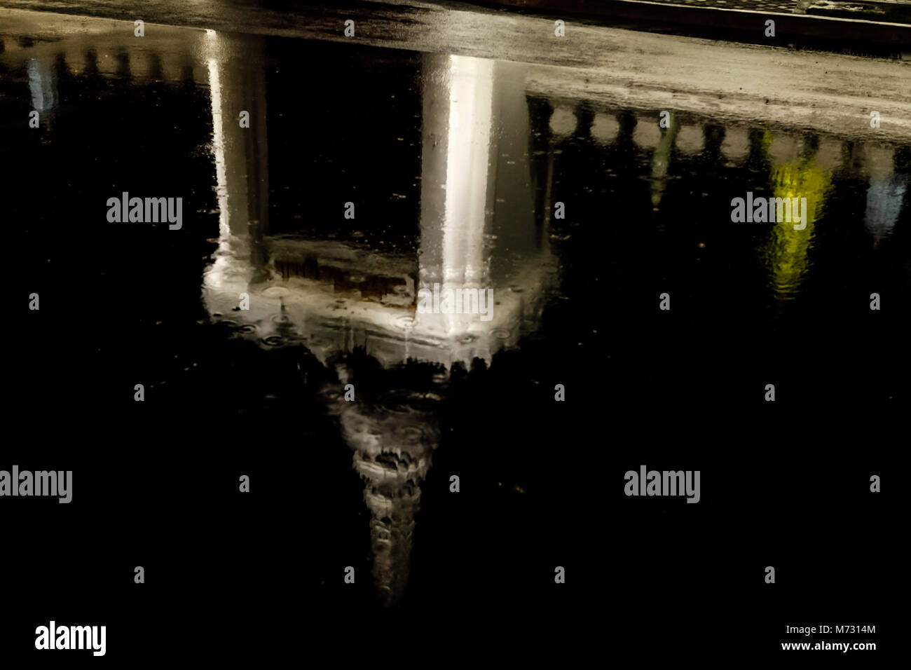 Riflessioni del Grand Palace in strada sotto la pioggia a Bangkok Foto Stock