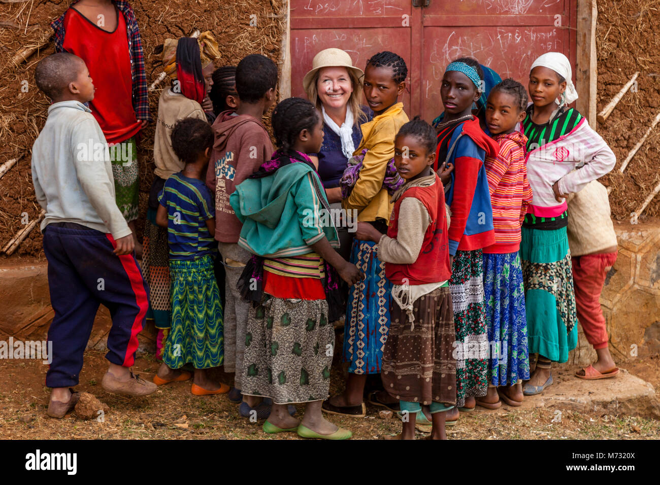 Bambini etiopi si raccolgono intorno ad un turista presso il mercato del sabato nel villaggio di Dorze di Chencha, Guge montagne, Gamo Gofa Zona, Etiopia Foto Stock