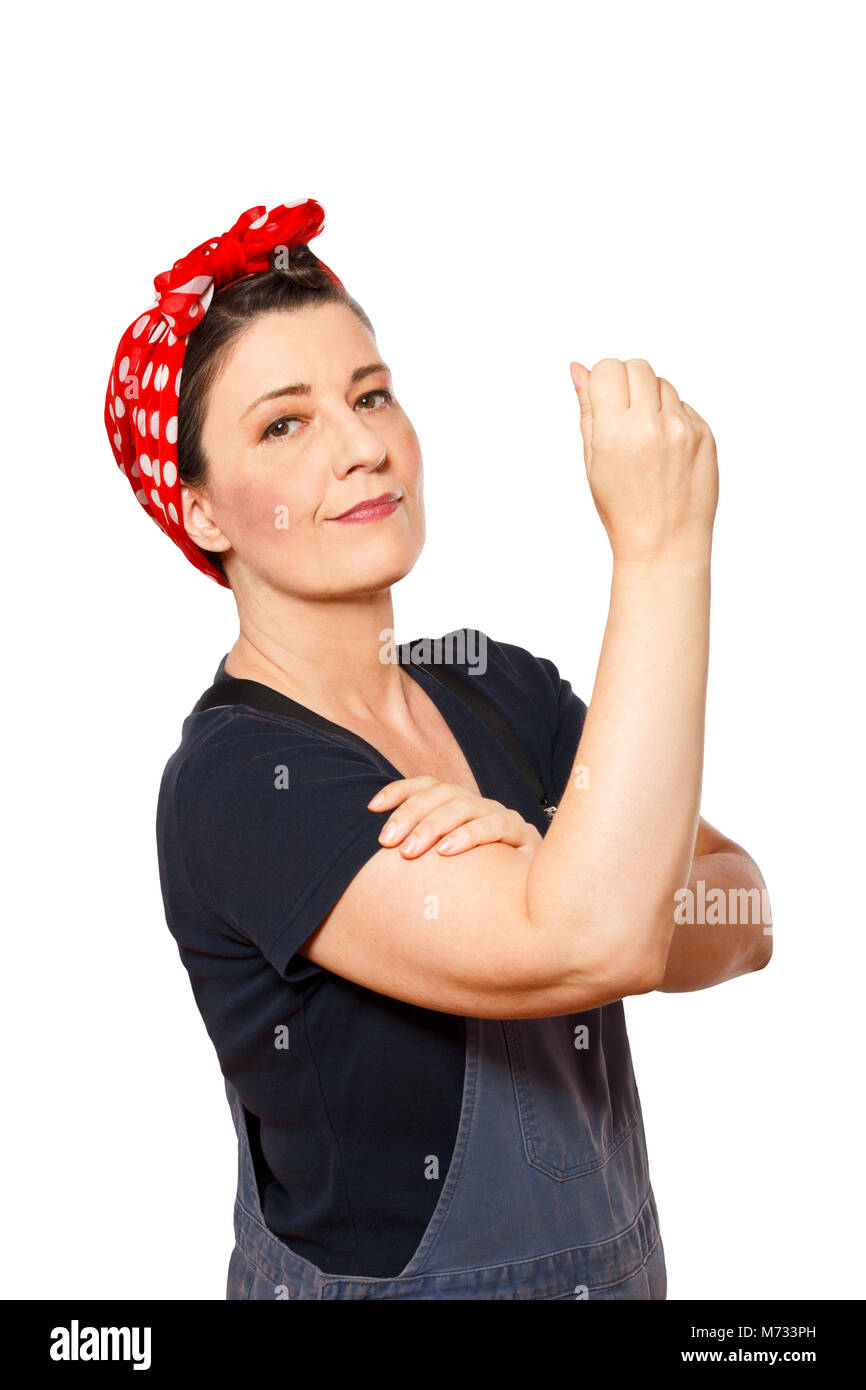 Sicuro di sé donna di mezza età con salopette da isolati su sfondo bianco, testo spazio, omaggio al lavoratore americano icona Rosie chiodatrice Foto Stock