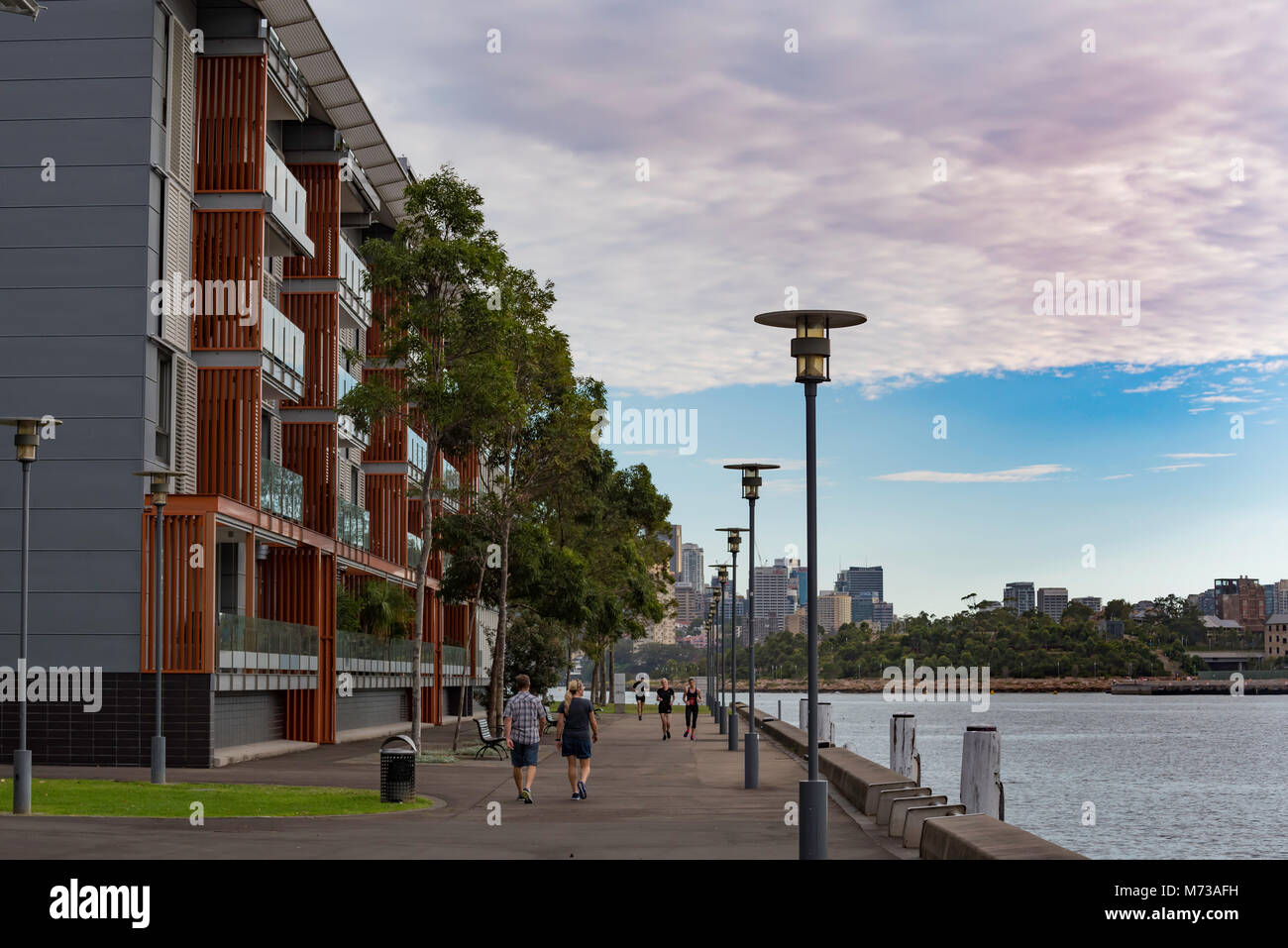 La gente camminare e di esercizio lungo una passeggiata accanto al Porto di Sydney nel Pyrmont, Australia Foto Stock