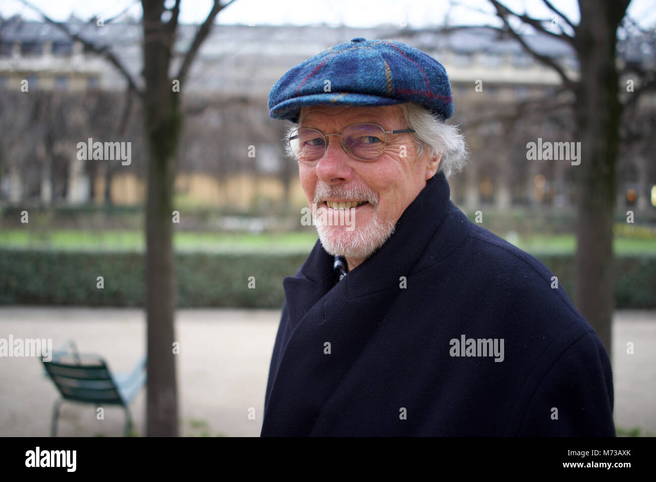 Uomo in pensione in Harris Tweed Hat - passeggiate nel parco della città Foto Stock