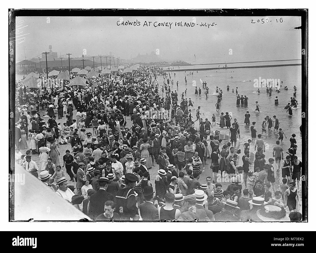 Questa immagine cattura grandi folle a Coney Island, una popolare destinazione di divertimento a Brooklyn, New York. La foto mostra l'atmosfera vivace e gli amanti della spiaggia che apprezzano le attrazioni. Foto Stock