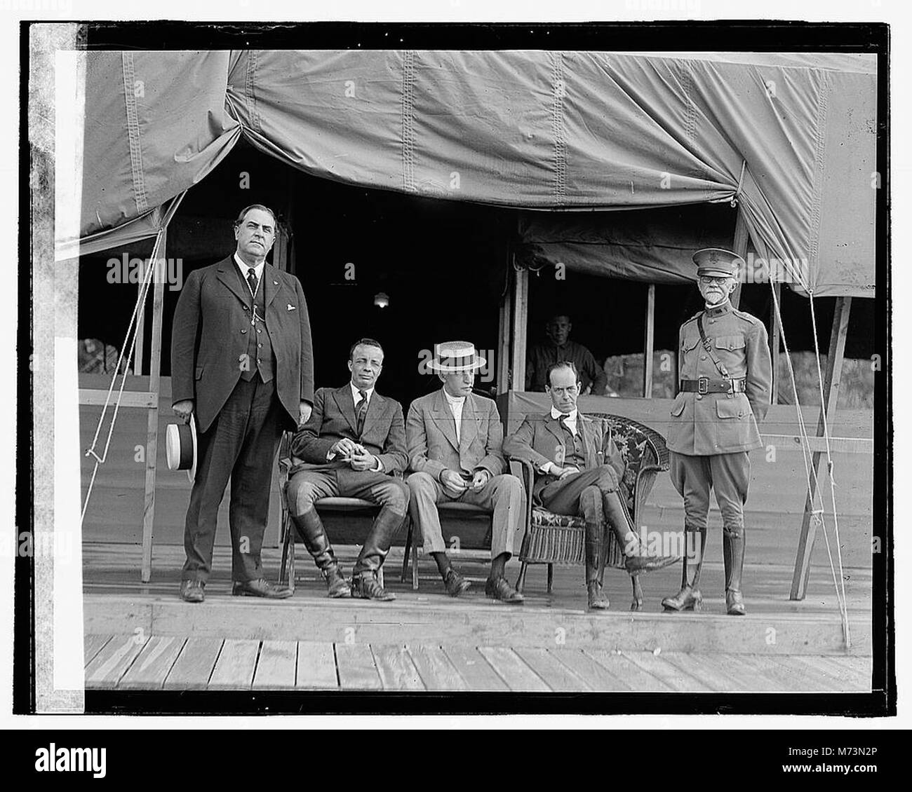 Cinque uomini sono mostrati in piedi fuori da un edificio di tenda, possibilmente in un contesto militare o di campeggio. La fotografia li cattura in un ambiente naturale, illustrando il loro abbigliamento e l'ambiente. Questa immagine offre informazioni sullo stile di vita o sulle condizioni del periodo di tempo. Foto Stock