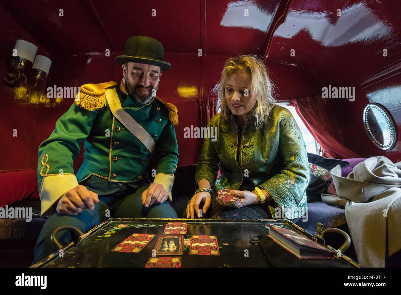 Londra, Regno Unito. 8 marzo 2018. L'artista inglese Alice Instone (R) dà una lettura di tarocchi con assistente al Barclay. Alice Instone presenta un nuovo progetto 'giocando a carte con mia nonna' in Canary Wharf per celebrare la Giornata internazionale della donna. Il progetto rappresenta anche arti visive dell ONU per donne arti HeForShe settimana. I visitatori sono invitati a unirsi alla sua arte magica Caravan a una varietà di occupato posizioni di Londra per una partita a carte o una lettura dei tarocchi utilizzando un mazzo di carte che ha progettato come un modo di riunire gli sconosciuti. Credito: Stephen Chung/Alamy Live News Foto Stock