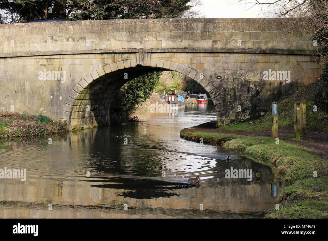 Kennet & Avon Canal nel West Berkshire con pittoresca strada di pietra ponte che attraversa il canale Foto Stock