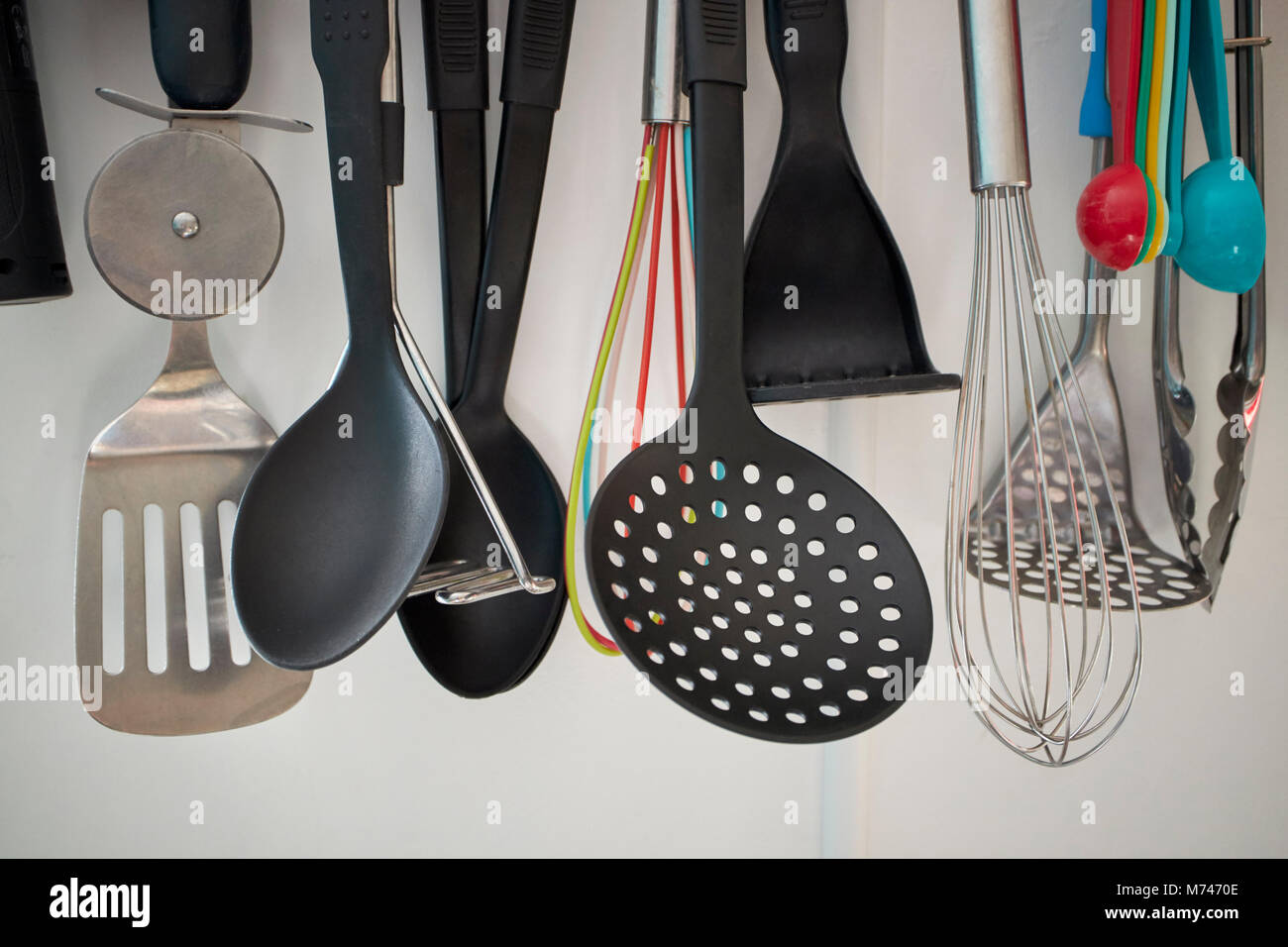 Varietà di utensili da cucina appeso su un rack in una cucina nel Regno Unito Foto Stock