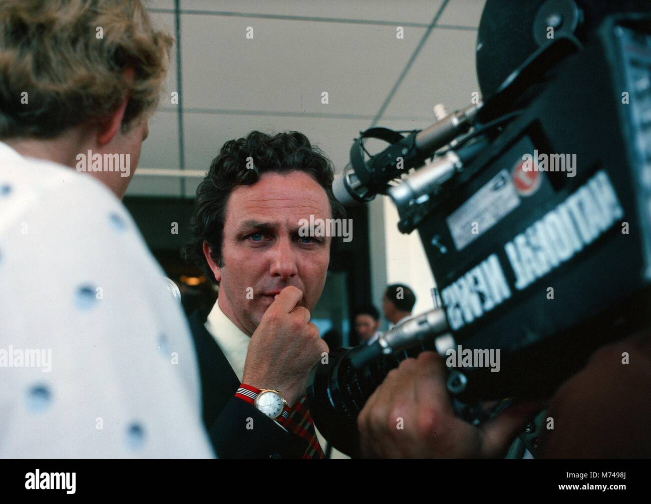 Una televisione reporter parla con il suo equipaggio mentre non riprese per il national news, 1965. () Foto Stock