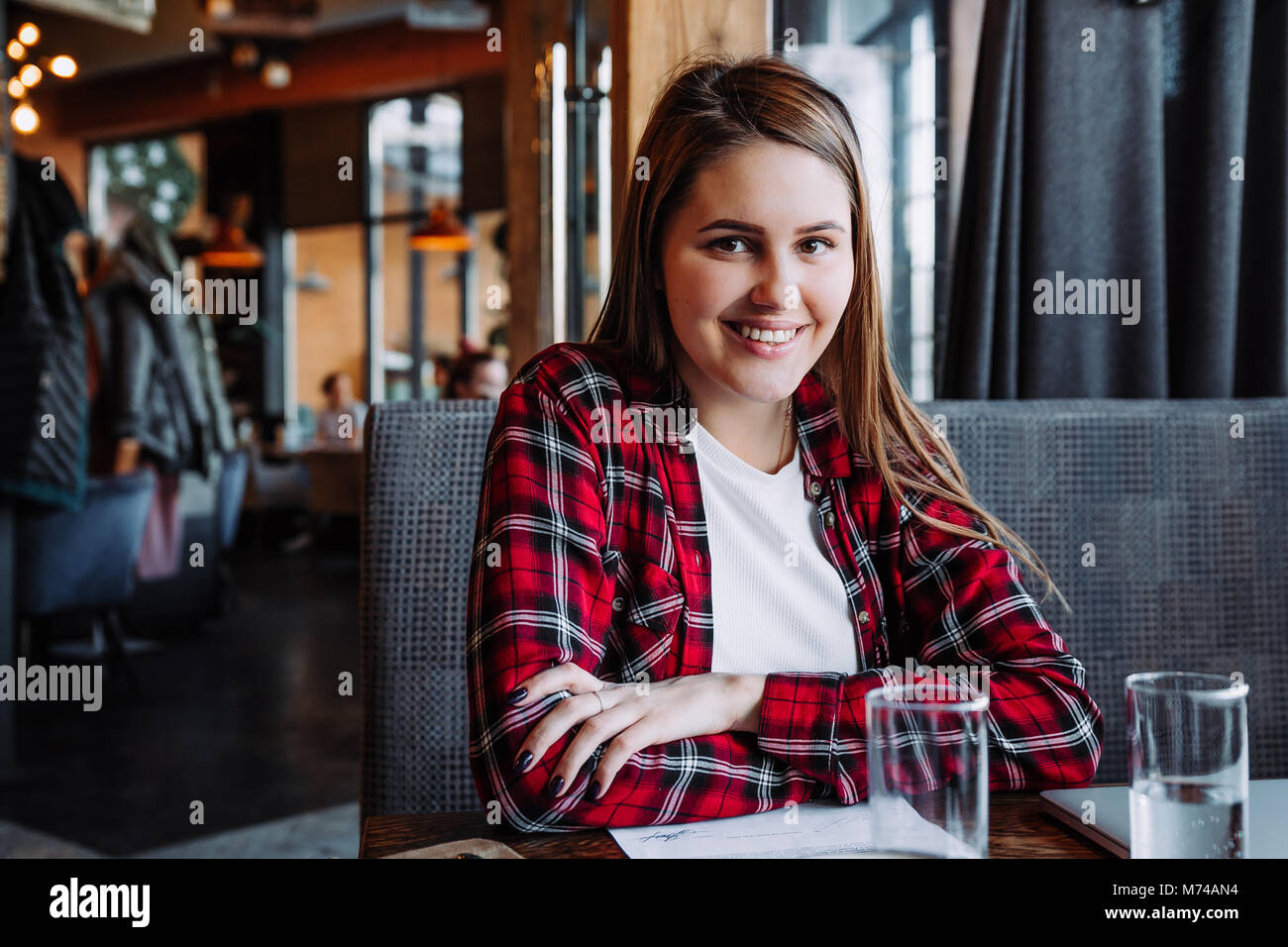 Bella bruna sorridente in telecamera in seduta cafe Foto Stock