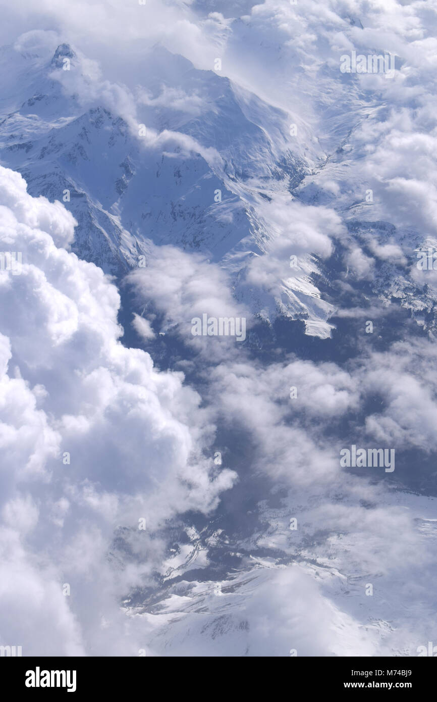 Vista panoramica delle Alpi italiane. Nuvole e innevate vette dal volo. Foto Stock