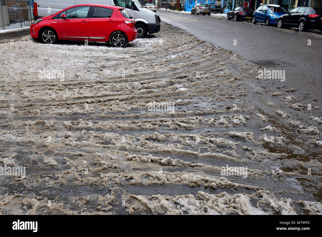 Prima loro era la neve poi granite, auto le tracce in granita con automobili parcheggiate, REGNO UNITO Foto Stock