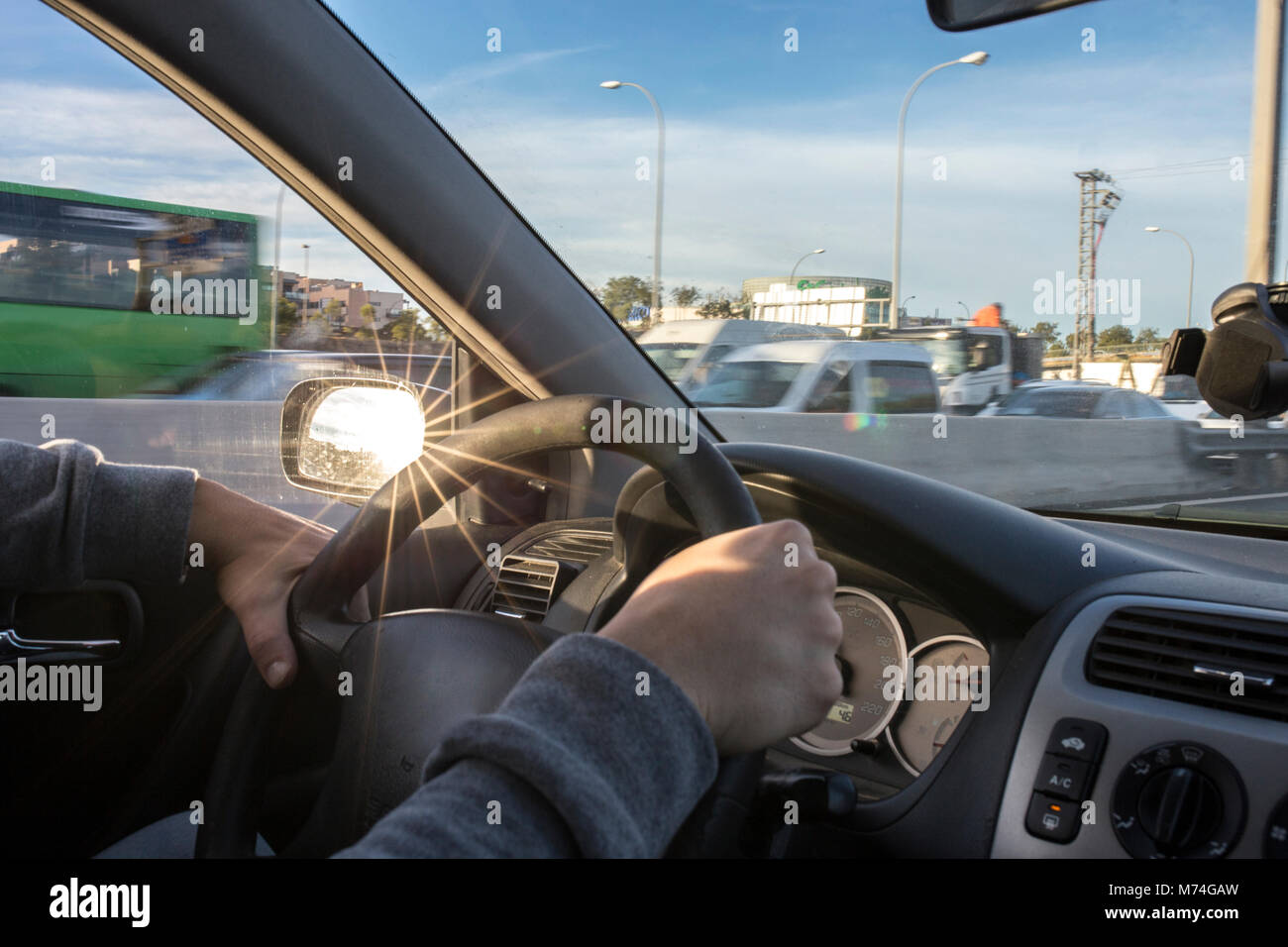 La guida con fastidiosi riflessi di sun sul retrovisore. Vista dall'interno della vettura Foto Stock