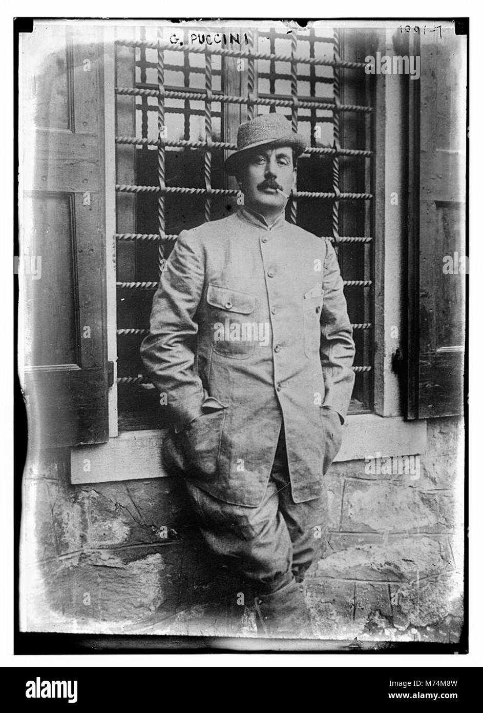 Ritratto del famoso compositore italiano Giacomo Puccini, raffigurato in una giacca con una sigaretta, catturando un momento di svago per la famosa figura della storia della musica. Foto Stock