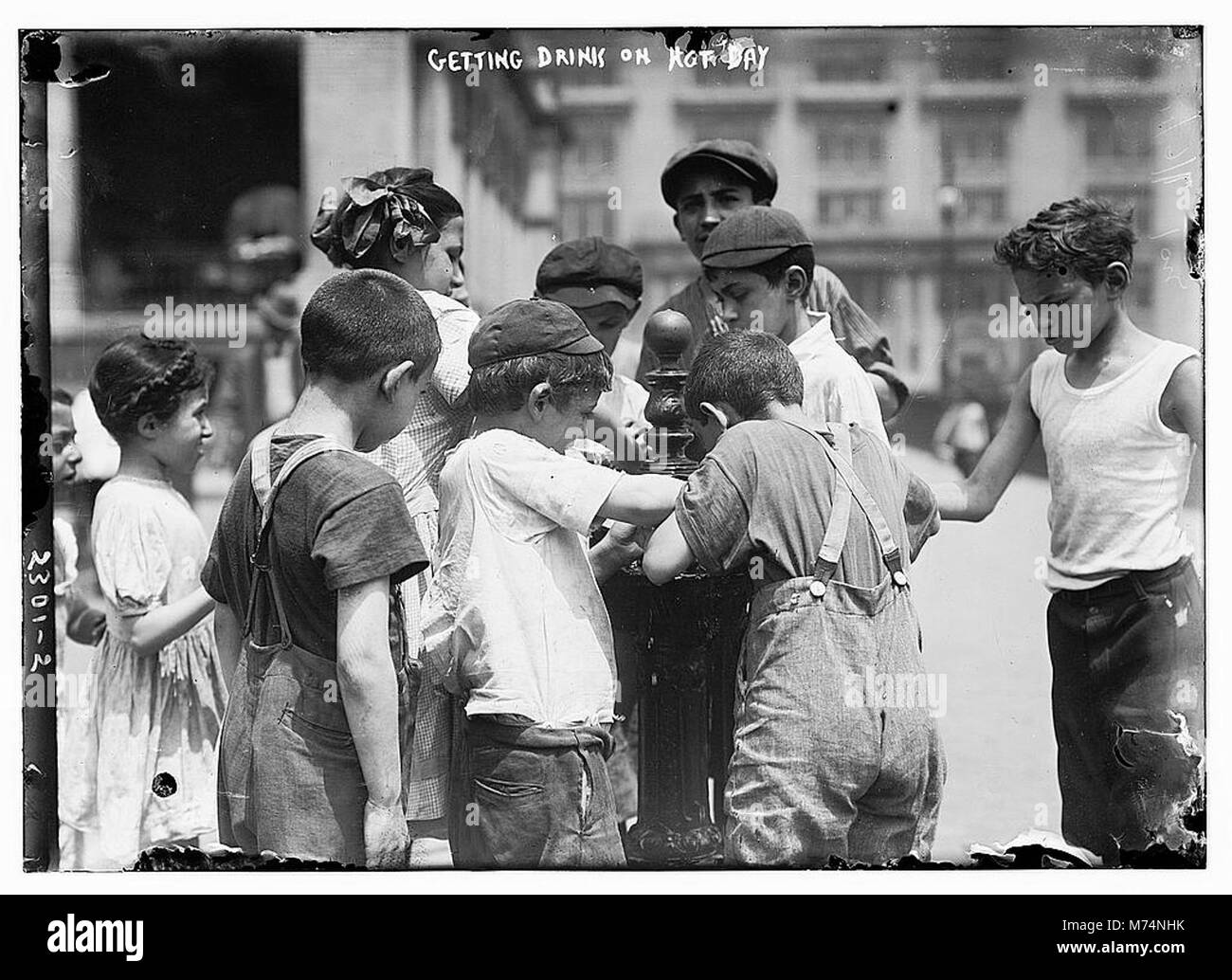 Una scena che cattura le persone che bevono in una giornata calda, mostrando la vita di tutti i giorni e il comportamento sociale durante le giornate più calde. Foto Stock