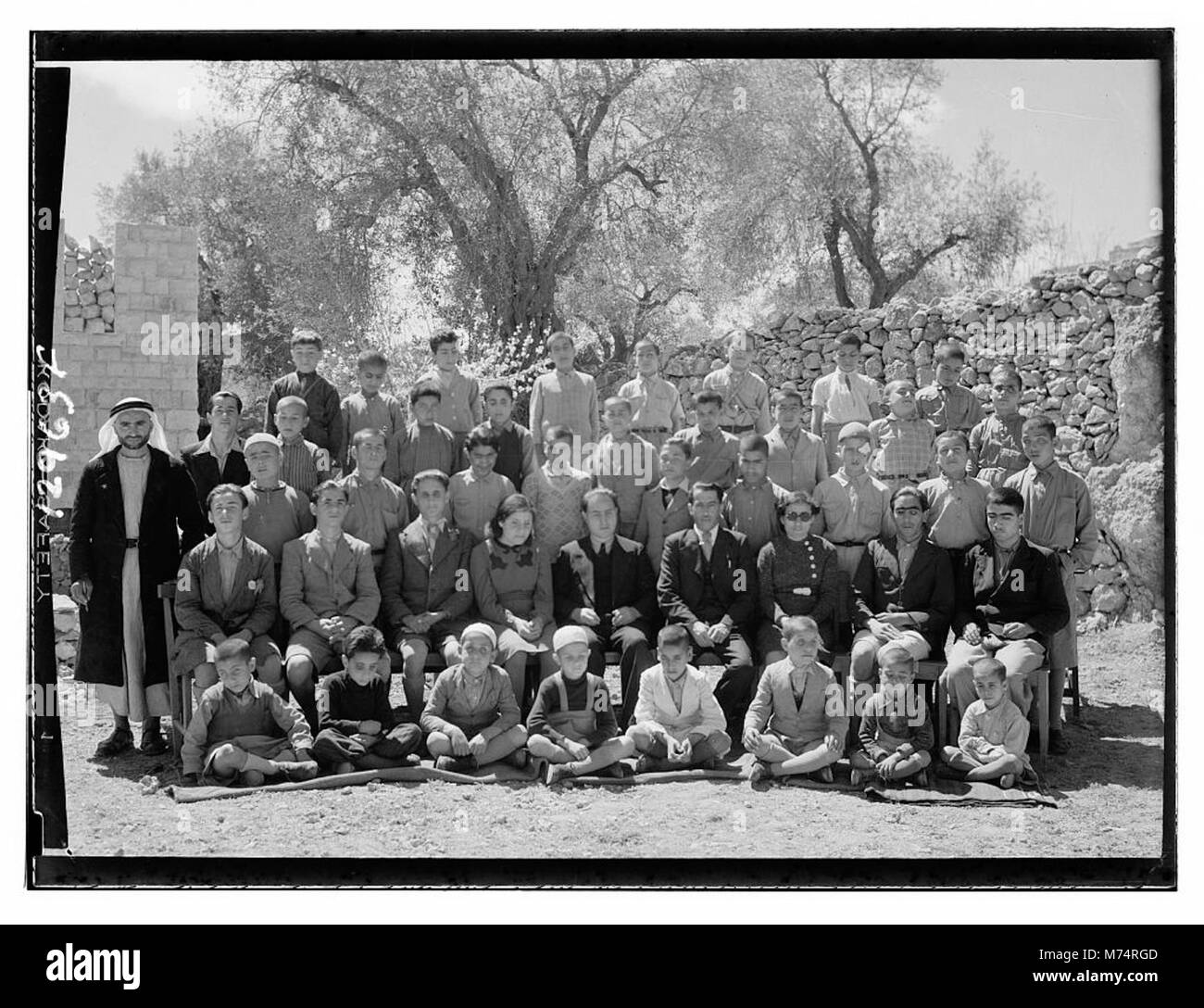 Questa immagine mostra un gruppo di individui in una scuola cieca di Hebron, che riflette i programmi educativi per i ciechi all'inizio del XX secolo. La fotografia evidenzia l'ambiente sociale e educativo della scuola. Foto Stock
