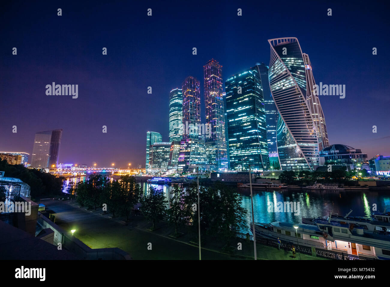 Paesaggio con grattacieli della città di Mosca di notte con illuminazione bello contro il blu scuro del cielo estivo Foto Stock