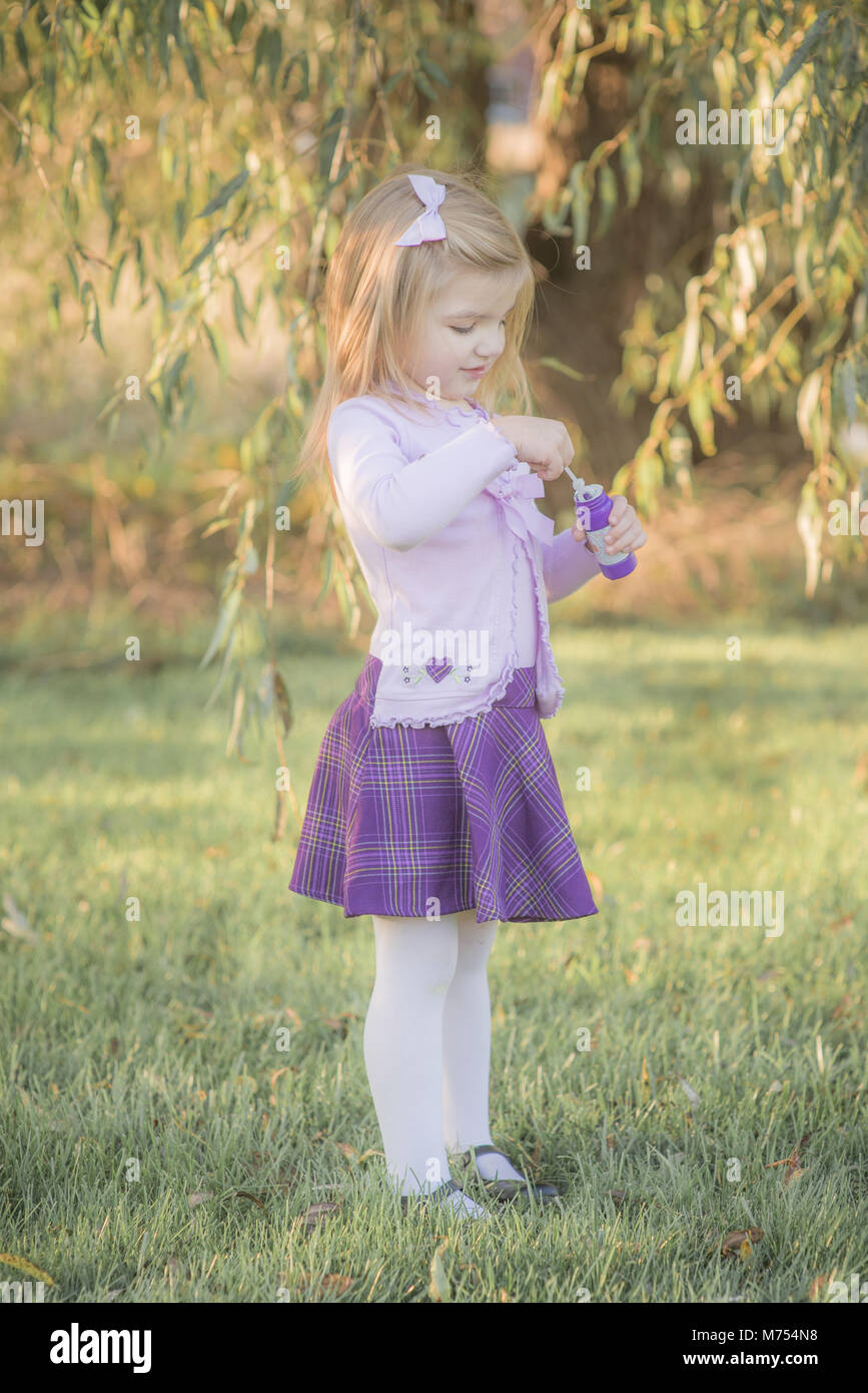 Giovane ragazza che gioca con le bolle all'aperto in autunno Foto Stock