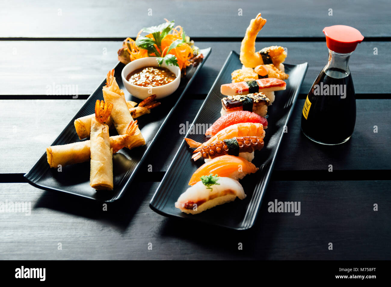 Vari tipi di sushi servita sulla pietra nera Foto Stock