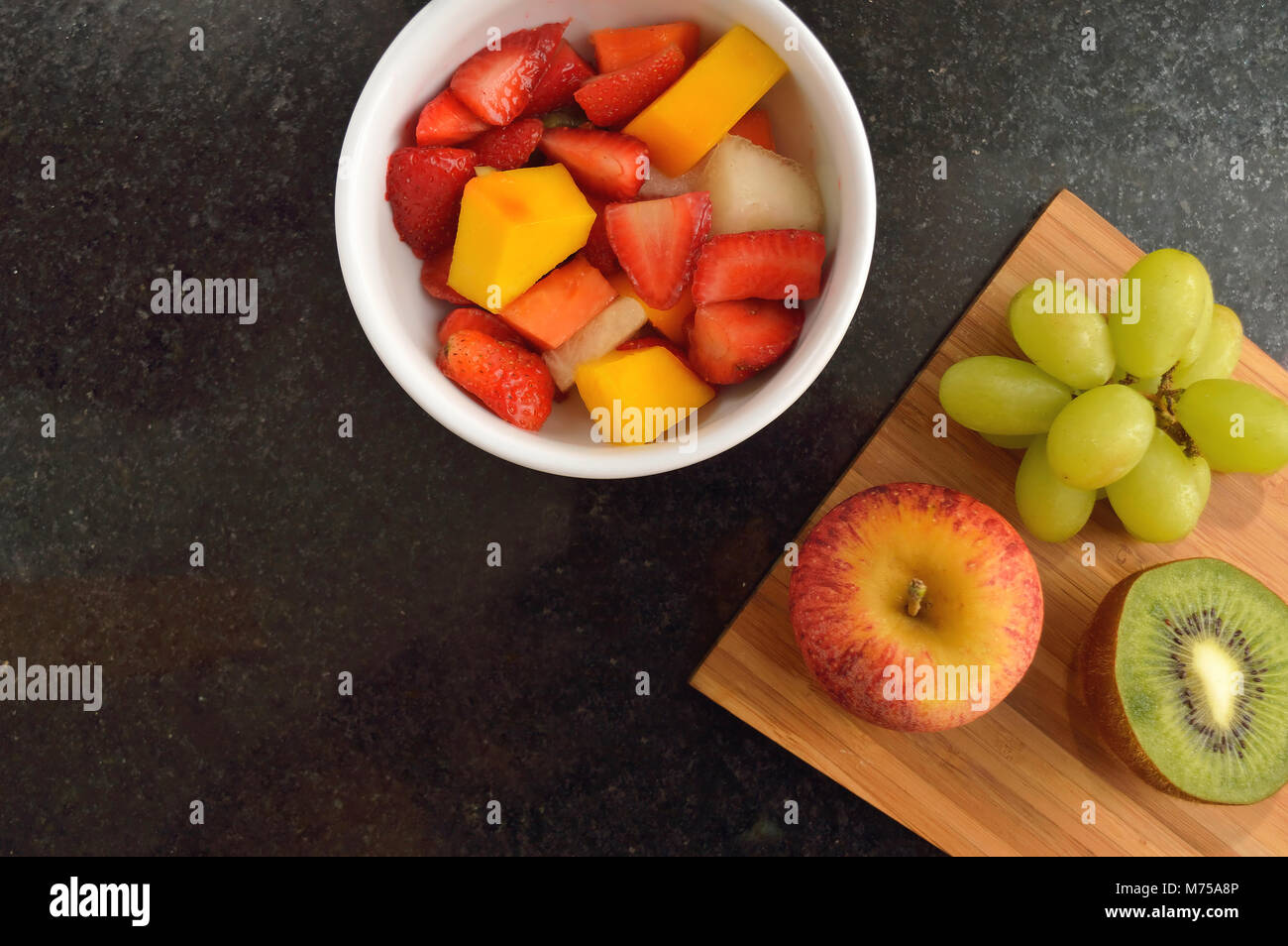 Ciotola con insalata di frutta su un bancone di granito visto da direttamente sopra Foto Stock