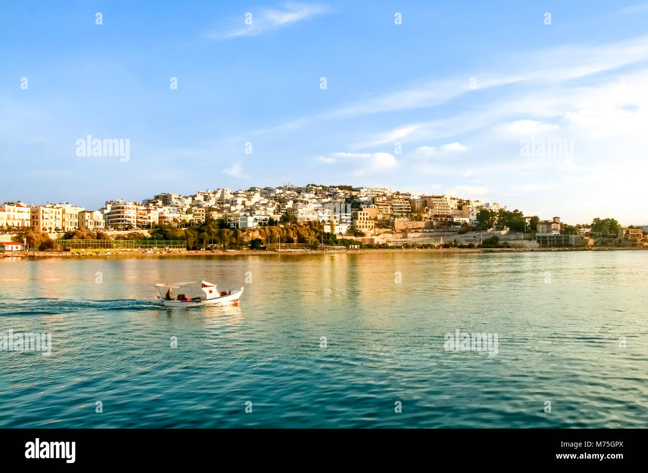 Pescatore di andare a pesca con una piccola barca in legno al sunrise. Kastela,Marina Zeas,Pireo, Grecia Foto Stock