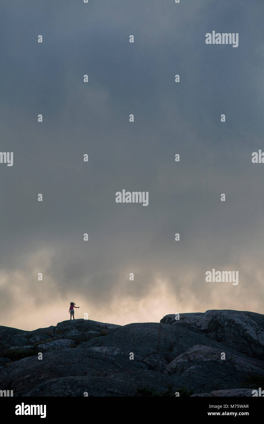 Bambina da sola sulla collina rocciosa isola Foto Stock