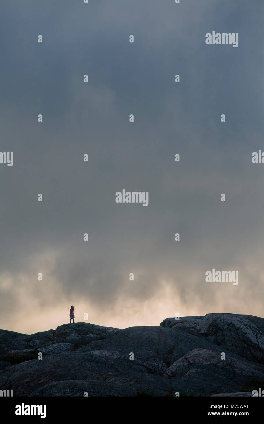 Bambina da sola sulla collina rocciosa isola Foto Stock